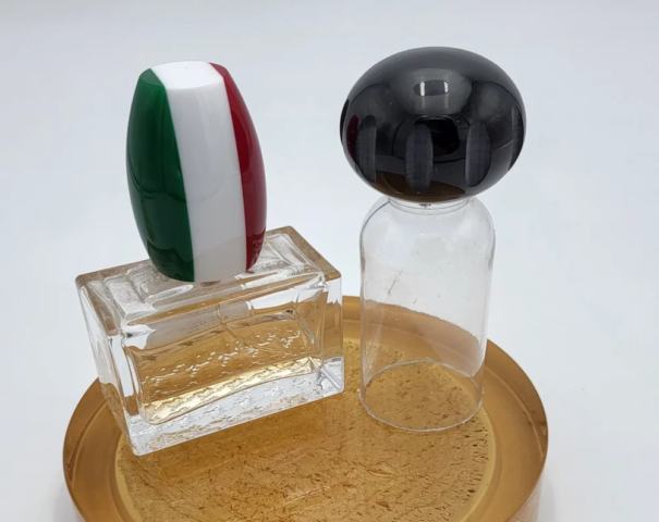 Tappi per flaconcini effetto bandiera e ovale su piatto ambra